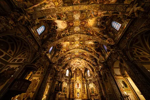 Stunning view of a Baroque church interior featuring detailed frescoes and intricate artwork.