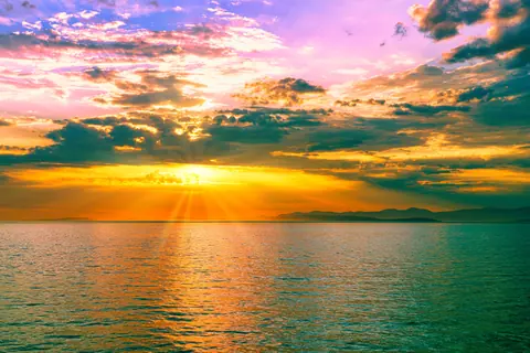 Stunning sunrise over the ocean with vibrant colors and dramatic clouds, ideal for nature and travel themes.