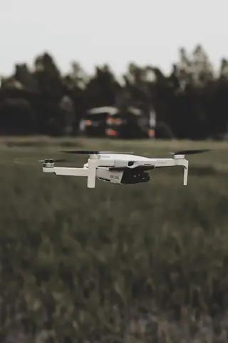 A drone captured mid-air in a serene field setting, showcasing modern technology in nature.