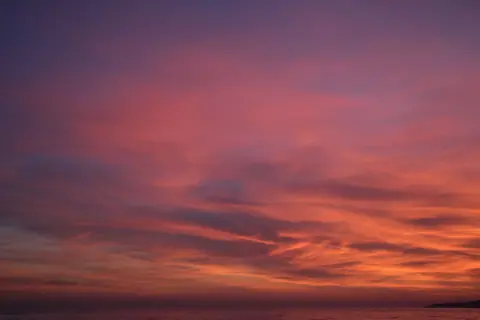 Breathtaking sunset with vibrant colors reflecting over the ocean waves.