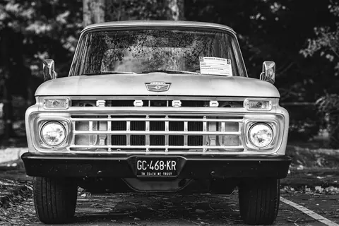 Classic Ford F-Series truck front view, black and white, capturing vintage charm.