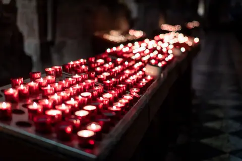 Candles illuminate the interior of a church in Lisbon, creating a warm and serene atmosphere.