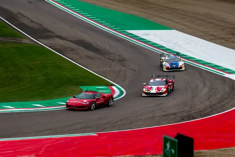 Exciting view of high-speed race cars navigating a professional racing track curve.
