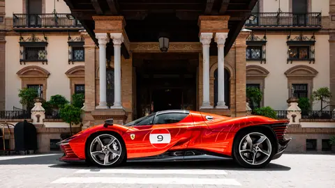 Sleek red sports car parked before a historic architectural facade.