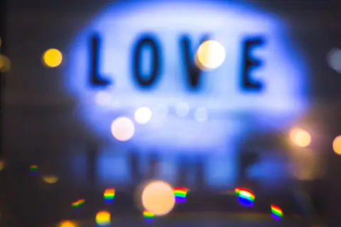 Blurred abstract bokeh image featuring the word 'Love' in bright lights.