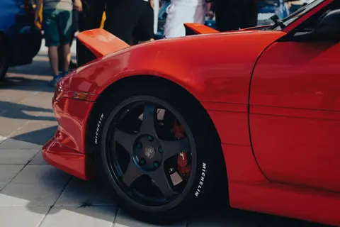 Close-up of a stylish red sports car on display at a car show.