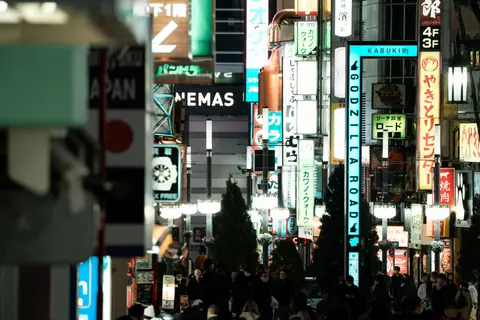 Explore the bustling nightlife of Shinjuku, Tokyo, with vibrant neon signs and a lively street scene.