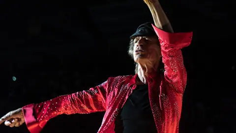 Mick Jagger waves arms while onstage during Rolling Stones concert - London, 22 May 2018