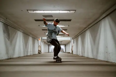 A young man enjoying skateboarding in a concrete tunnel, showcasing urban adventure and freedom.