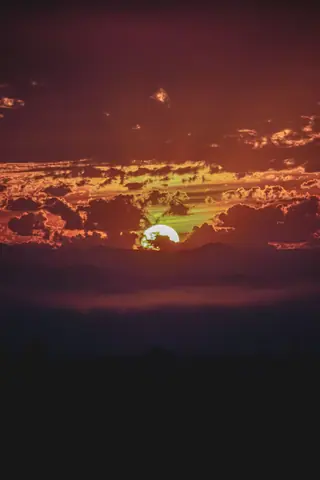 A vibrant sunset with dramatic clouds turning the sky into a canvas of fiery hues.