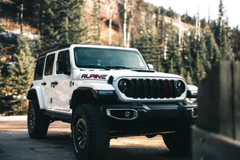 A Jeep Wrangler parked in the scenic forest of Jasper, Alberta.