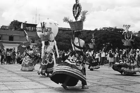 Black and white photo capturing traditional dancers in Oaxaca City, Mexico.