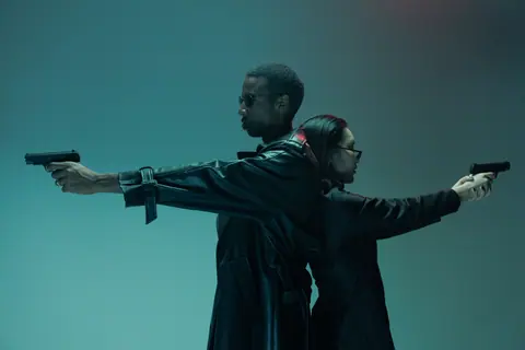 Two adults back-to-back, holding handguns, in a conceptual cyberpunk-like setting with cool tones.