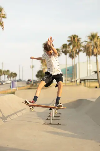 A young skateboarder skillfully performs a trick on a sunny day at a skate park in Texas. Perfect for active lifestyle imagery.