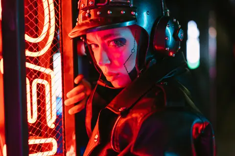 Close-up of a woman in cyberpunk attire with neon lighting, exuding a futuristic vibe.