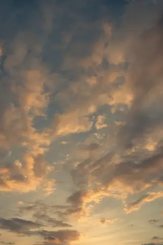 A serene sky filled with dramatic clouds during a beautiful sunset, evoking peace.