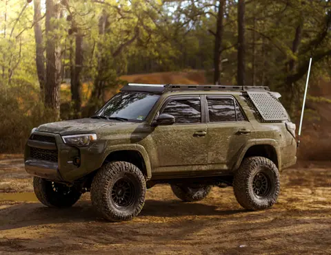 A rugged SUV off-roading on a muddy forest trail, showcasing adventure and freedom.
