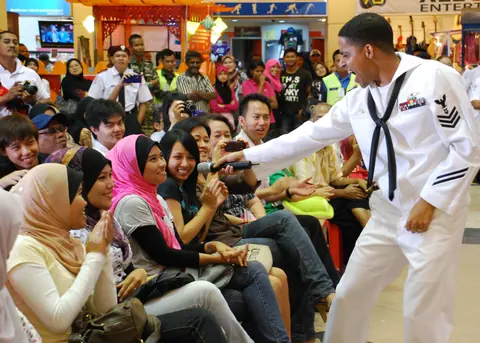 US Navy 110610-N-VP123-137 Musician 1st Class Christopher Sams enlists the help of the audience for a Michael Jackson song during a concert at Kuan