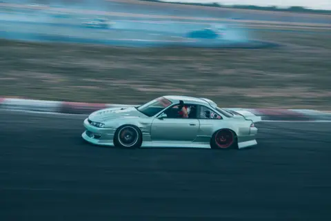 Experience the thrill of drift racing with this dynamic image of a car speeding on a track in Colorado Springs.