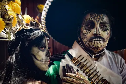 Colorful face paint and costumes at Dia de los Muertos festival.