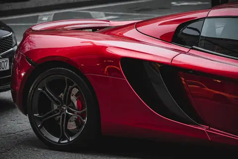 Stylish close-up of a red luxury sports car parked on a city street.