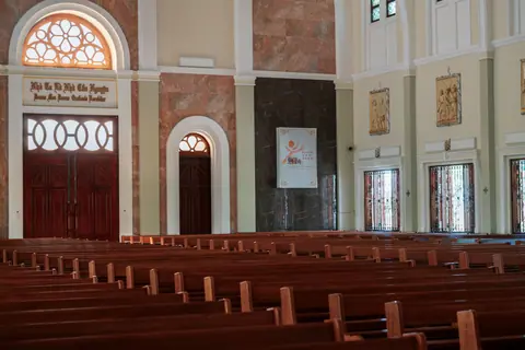 A serene empty church interior showcasing arches and elegant wooden pews, ideal for religious spirituality themes.