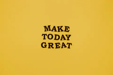 Simple and motivational quote 'Make Today Great' on a minimalist yellow background for inspiration.