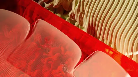Artistic abstract with bright red and beige patterns and textures.