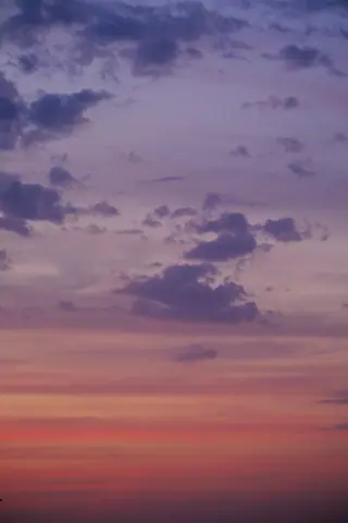 Stunning sunset sky with vivid purple and pink clouds, creating a serene ambiance.