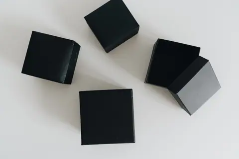 Aesthetic flat lay of black boxes open on a clean white surface.