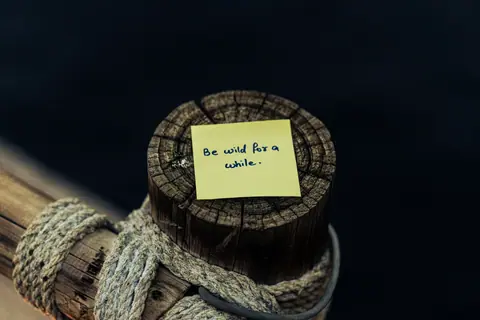 Close-up of a motivational note on a wooden pole with rope in Dubai.