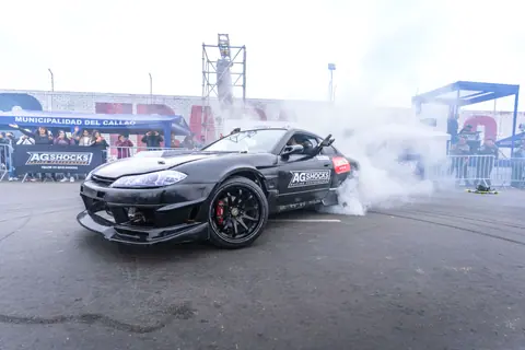 Nissan Silvia S15 performing a drift at a motorsport event in Callao, Peru with spectators watching.