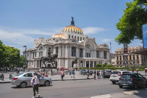 View of the iconic Palacio de Bellas Artes surrounded by bustling city life in Mexico City.