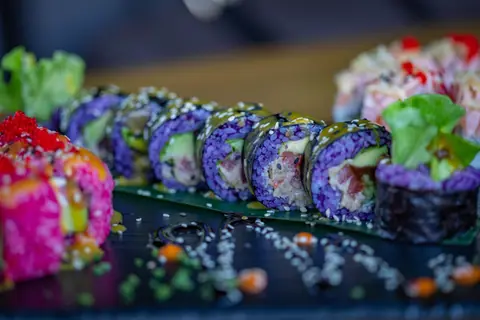 Close-up of colorful sushi rolls with vibrant ingredients and sesame seeds, perfect for food photography.