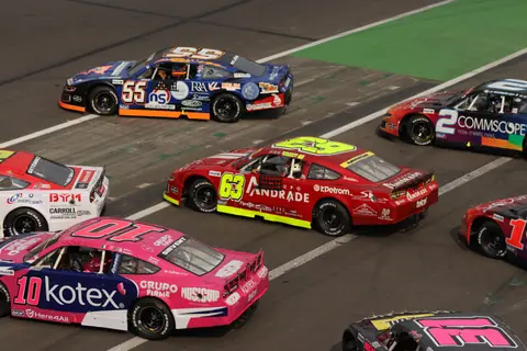 A thrilling NASCAR race taking place in Mexico City, showcasing colorful race cars on the track.