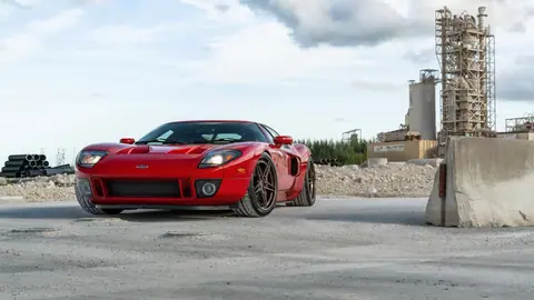 Red Ford GT Supercar in Industrial Landscape Ultra Sharp 8K Wallpaper - backiee