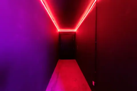 A vibrant neon-lit corridor featuring a striking blend of red and purple lights.