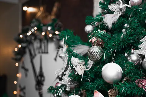 Festive Christmas tree with shimmering silver ornaments and sparkling lights.
