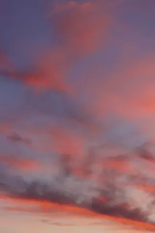 Vivid pink and purple sunset sky captured over Jönköping, Sweden with wispy clouds accentuating the tranquil evening.