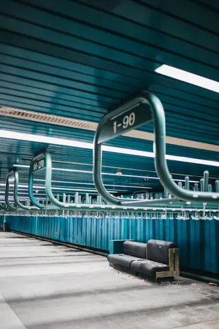A modern and illuminated subway station featuring sleek metal structures and a futuristic design.