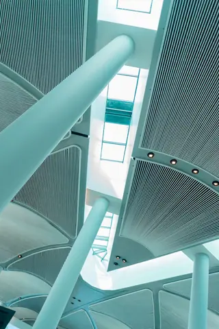 A low-angle view of a modern interior with sleek columns and a skylit ceiling.