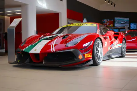 Showroom display of a red Ferrari sports car with racing decals and vibrant design.