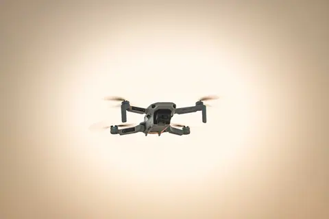 Captivating shot of a drone in flight against a serene sky at dusk, showcasing modern aerial technology.