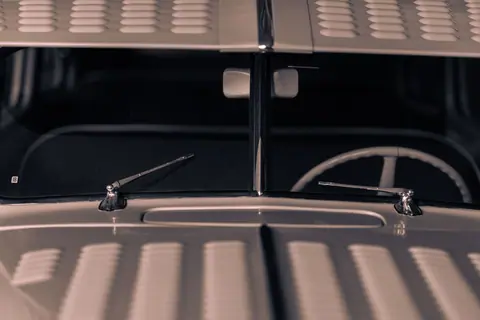 Detailed view of a classic car's windshield and chrome wipers, showcasing automotive design.