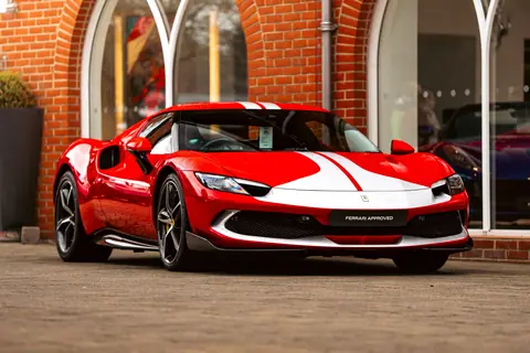 A striking red Ferrari sports car with white racing stripes displayed outdoors in Southampton showroom.