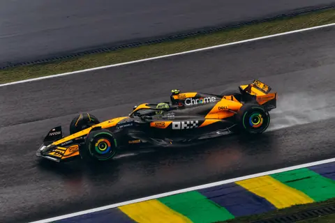 Dynamic shot of a Formula 1 car racing on a rainy track, showcasing speed and precision.