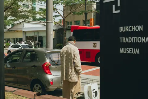 Street view near Bukchon Traditional Museum, Seoul with a person walking by.