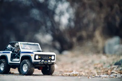 Close-up photograph of a Ford miniature toy car set outdoors in a natural setting, ideal for adventurous themes.