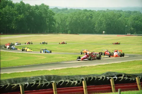 A thrilling outdoor car race featuring colorful formula cars speeding around a track.