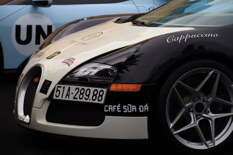 Detailed view of a luxury sports car front displaying custom decals and license plate.